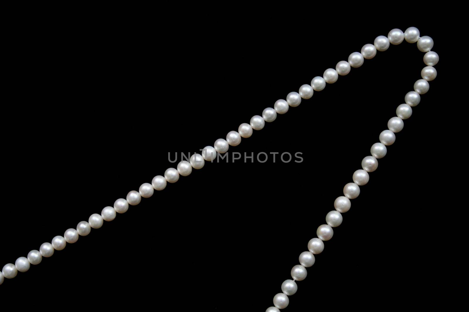 White pearls on the black velvet  background