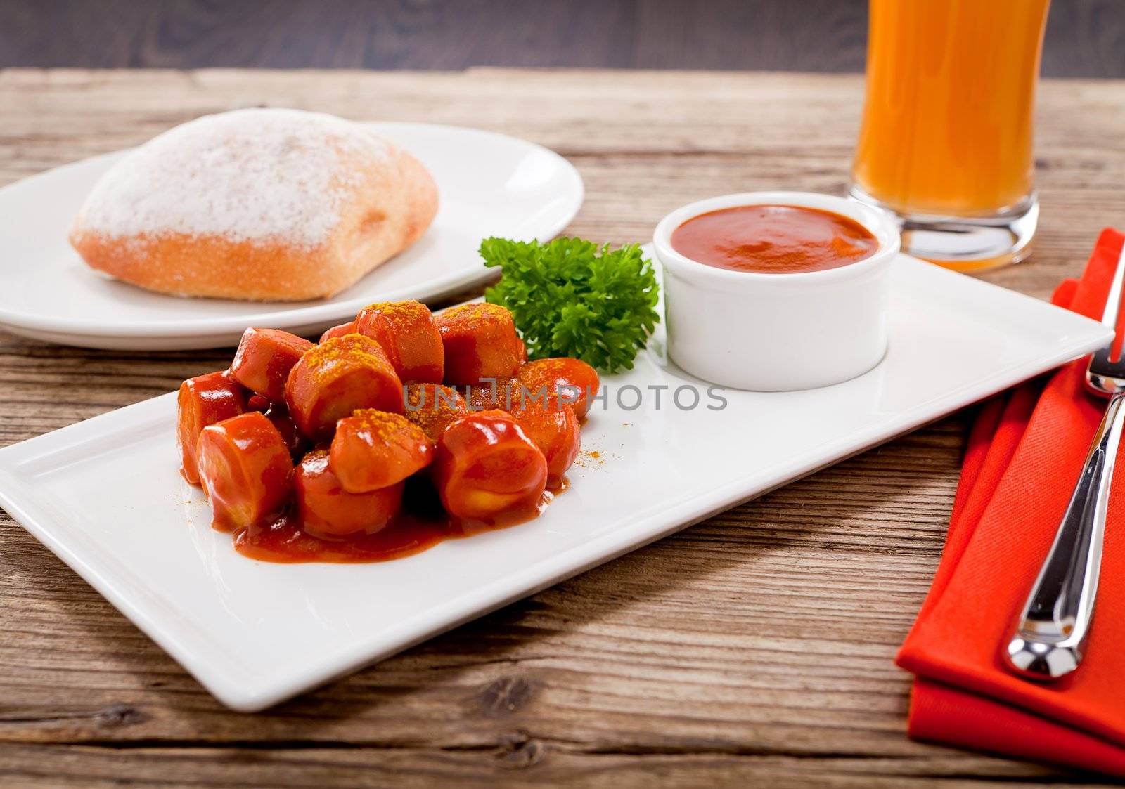 curry wurst spicy sausage with curry and ketchup on wooden background