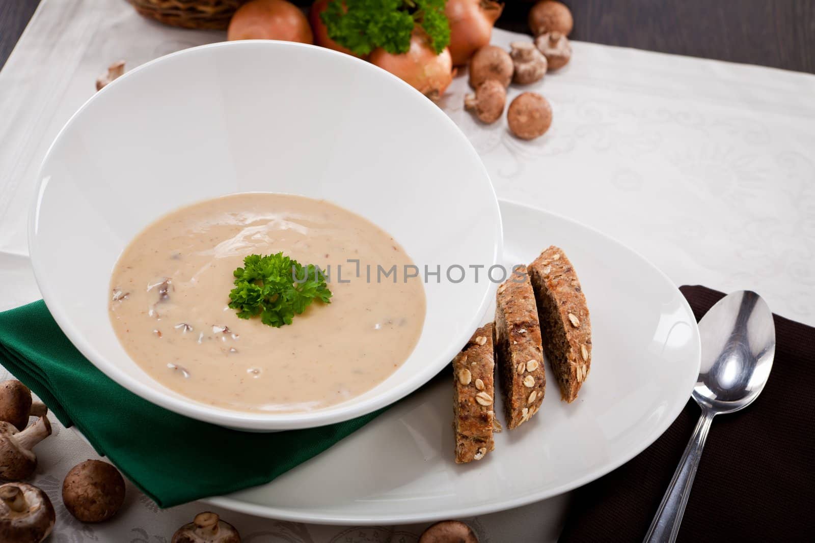 fresh chmapignon cream soup with parsley decorated on wooden table