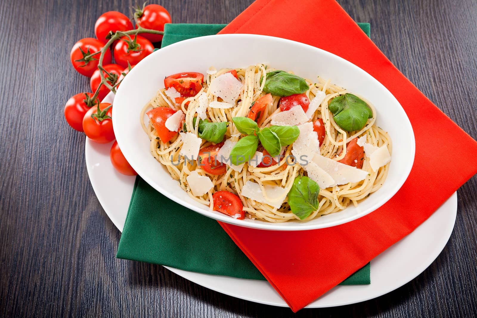 fresh tasty pasta spaghetti with tomatoes parmesan and basil on table