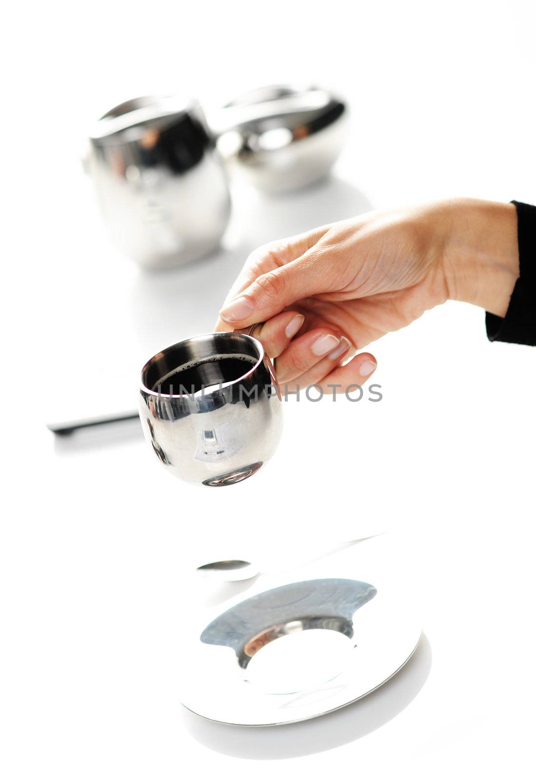 Hands of a woman holding a cup of coffee by stokkete