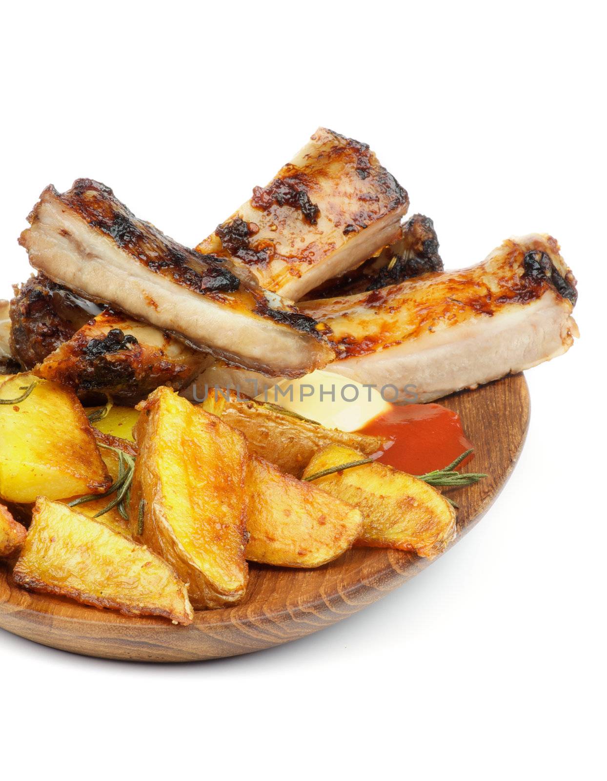 Barbecue Pork Ribs and Roasted Potato Wedges with Ketchup and Cheese Sauce closeup on Wooden Plate