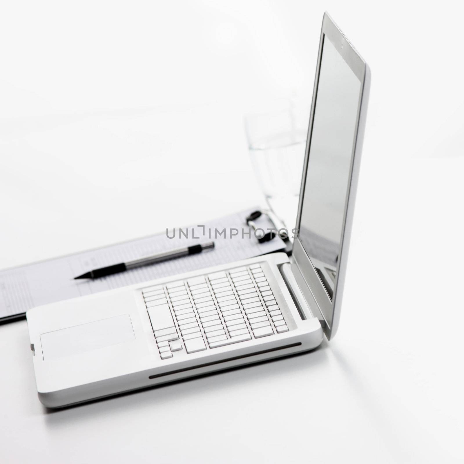 workplace, laptop, clipboard, pen, white background by stokkete