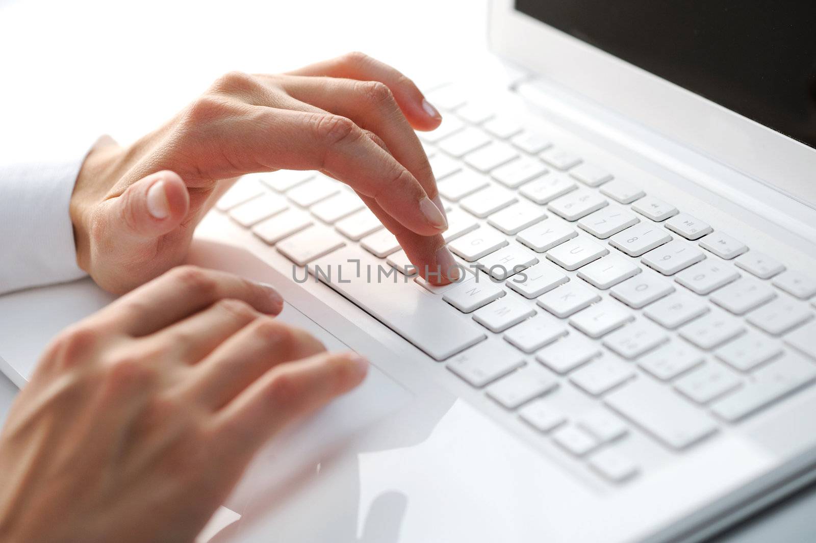 Female hands typing on a white computer keyboard