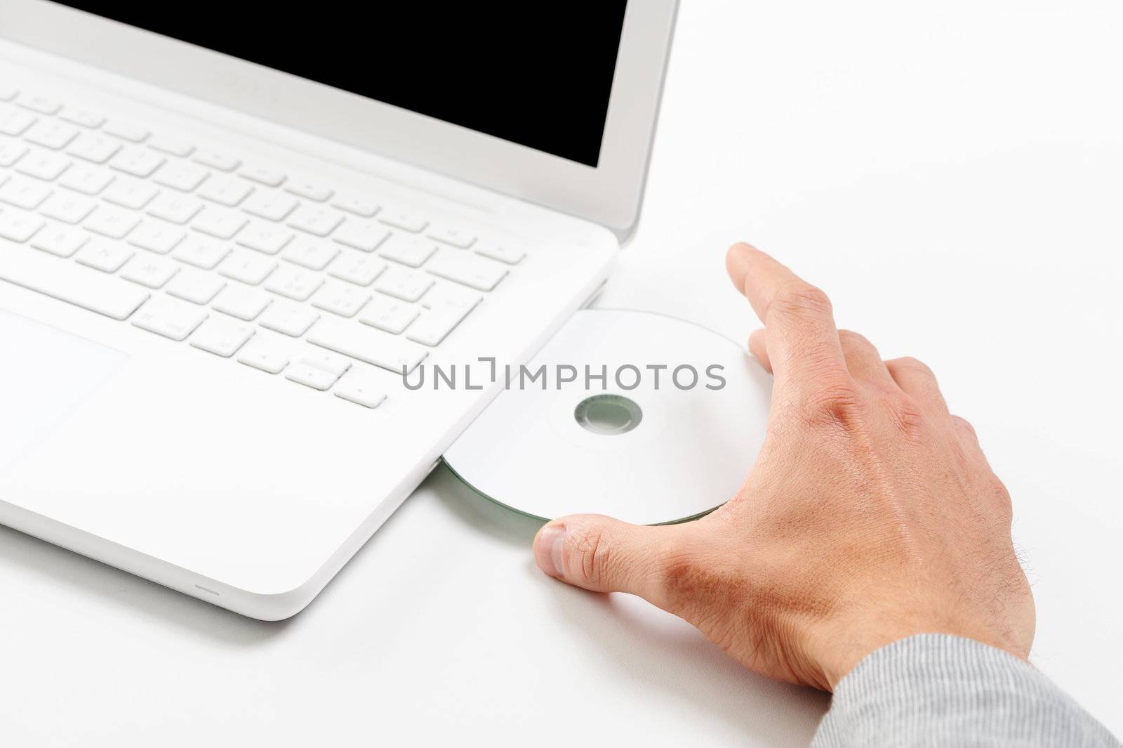 Businessman inserting a cd on white laptop