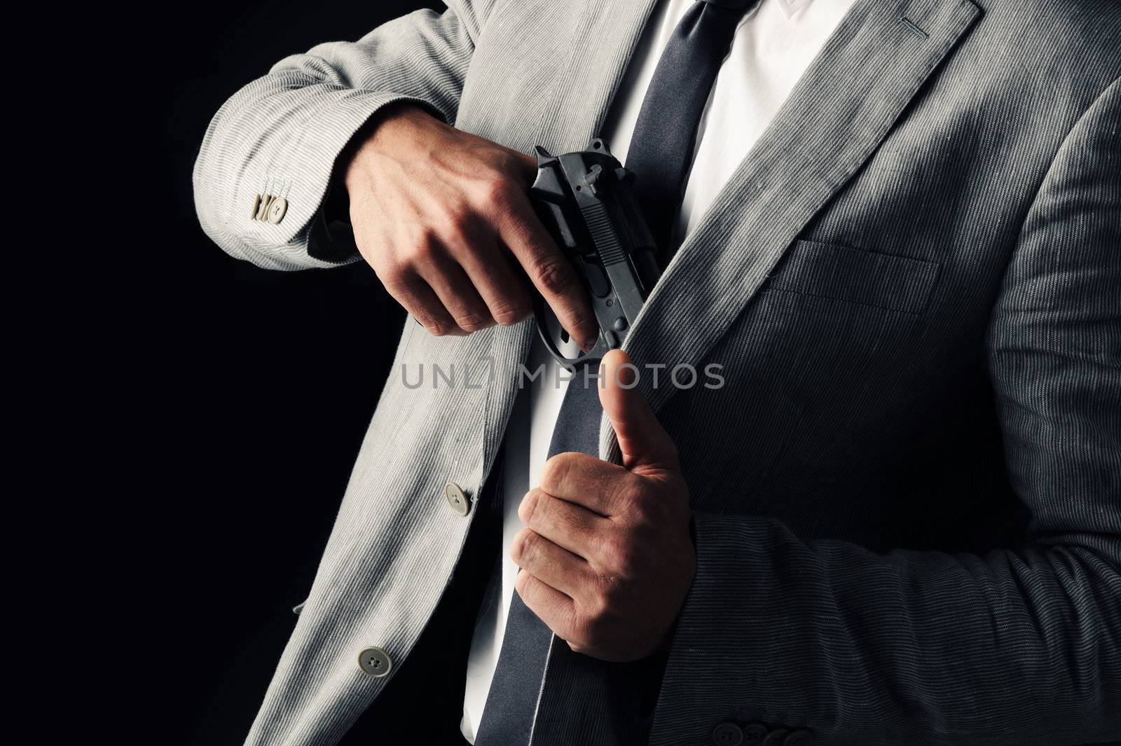 secret-agent guy  holding a gun, black background by stokkete