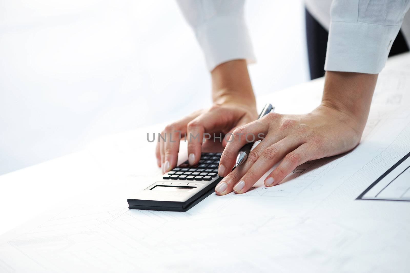 woman's hands with a calculator  by stokkete