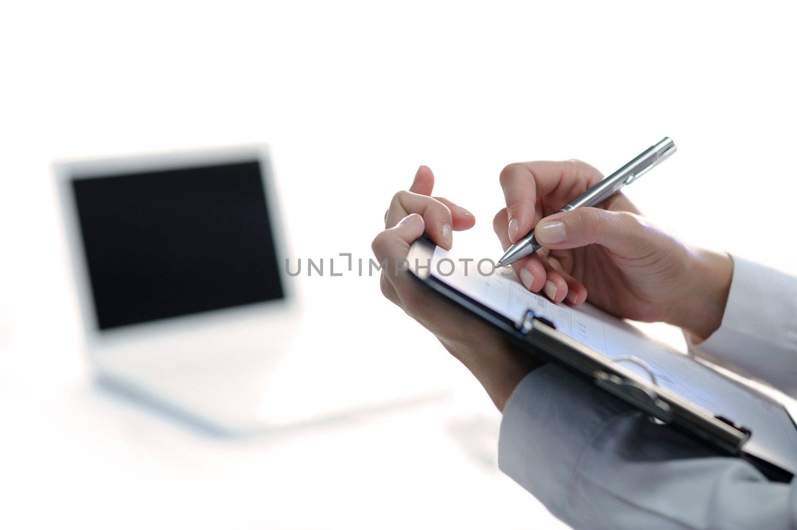 Business woman taking notes, laptop on background