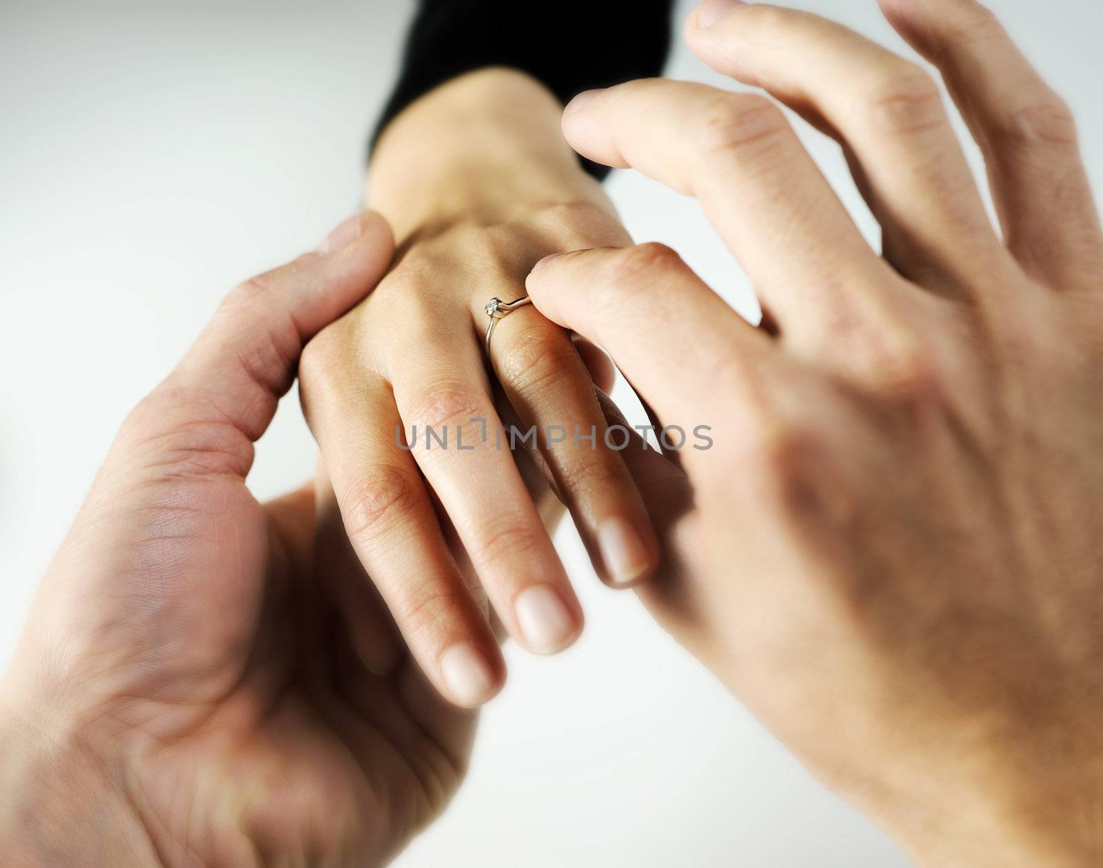 man putting a  ring with a brilliant on a female hand, love concept