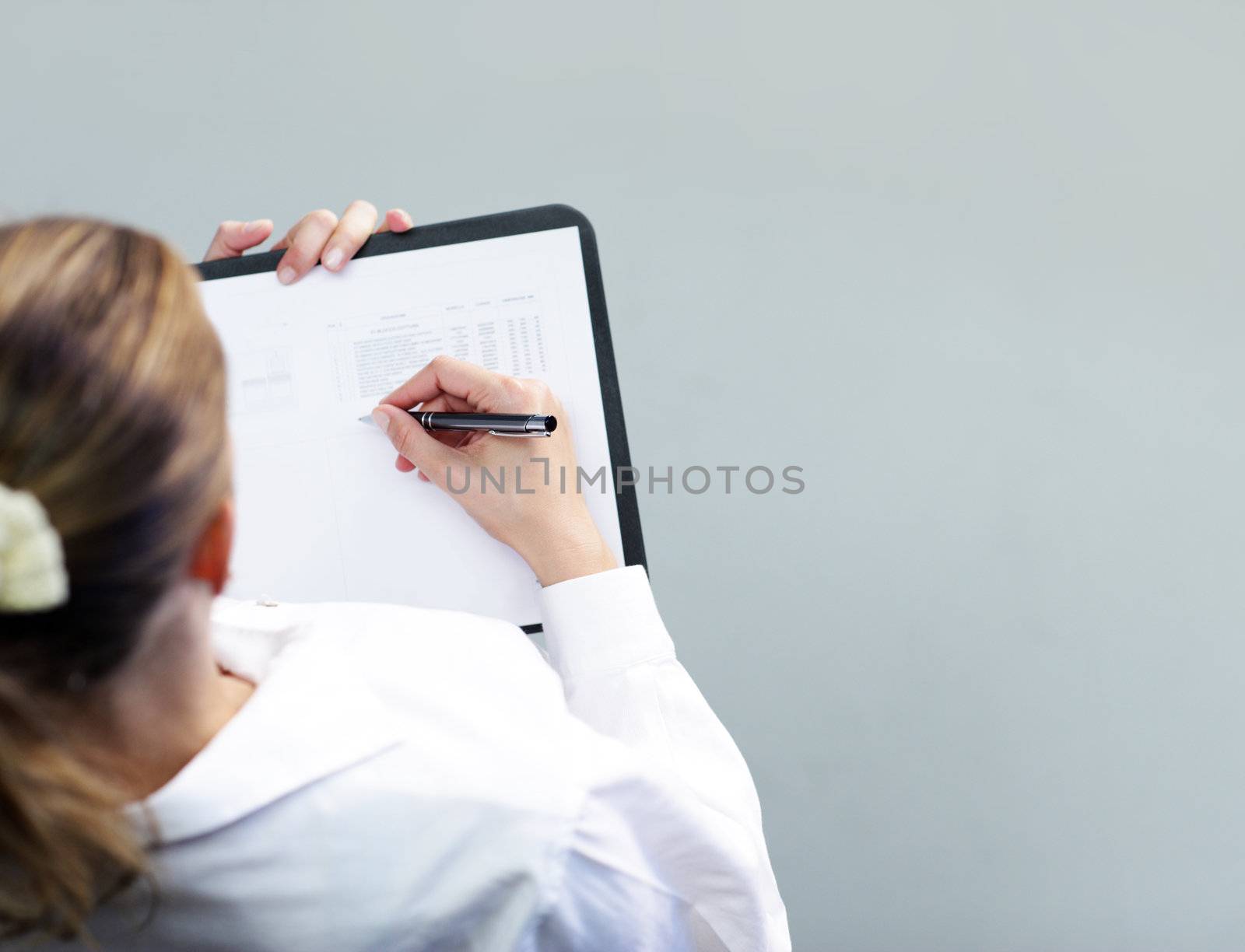 Top view  of a Business woman writing on a clipboard
