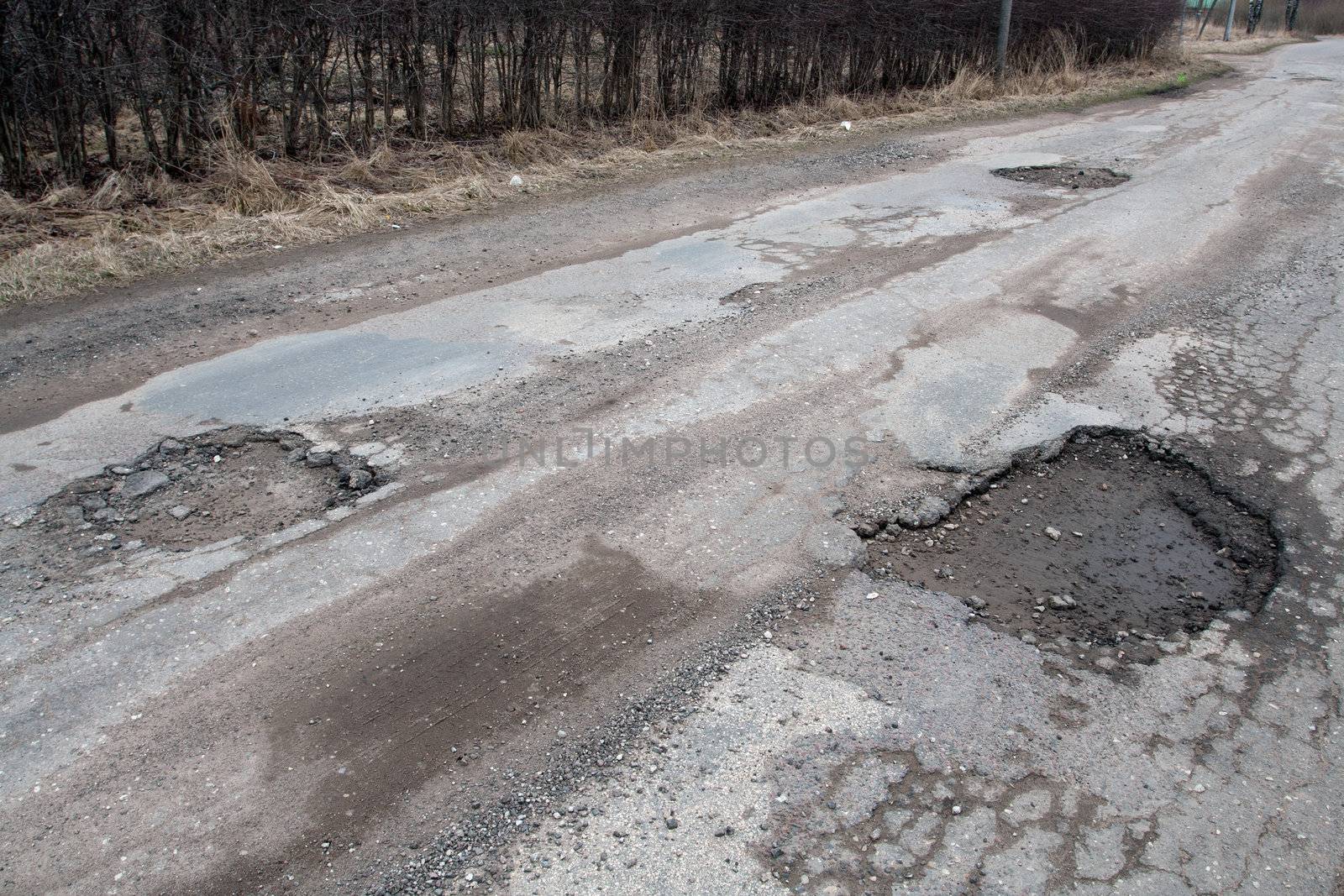 Damaged asphalt road after winter. by ints