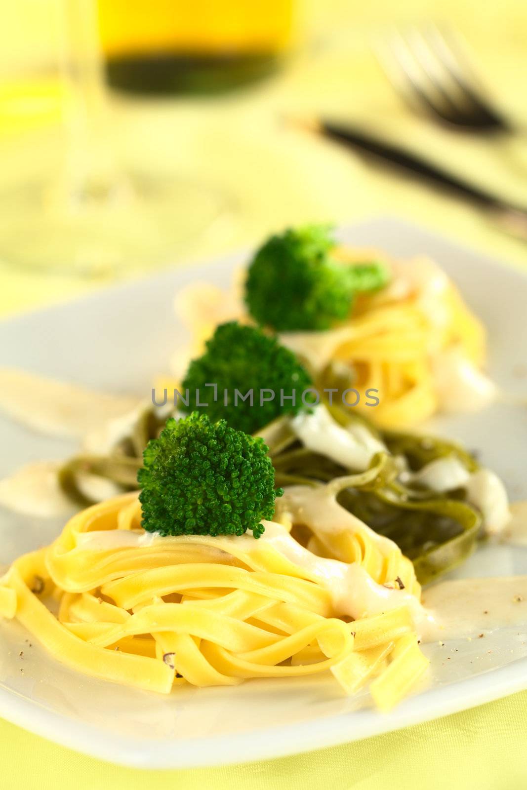 Broccoli on fettuccine with bechamel sauce and ground pepper (Selective Focus, Focus on the front of the first broccoli)