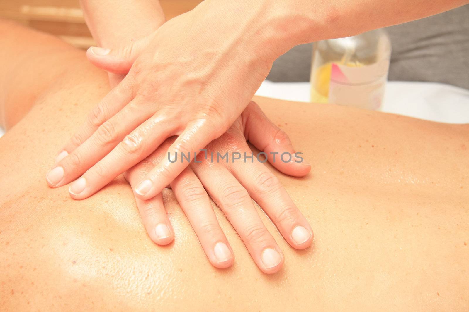 A female masseur giving massage, detail of hands on back