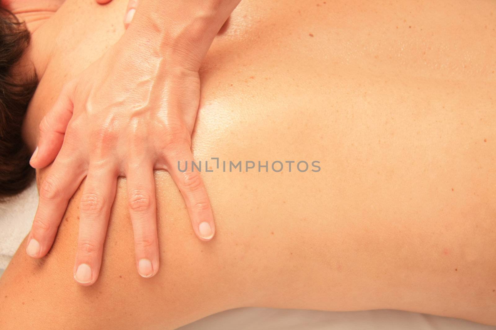 A female masseur giving massage, detail of shoulders