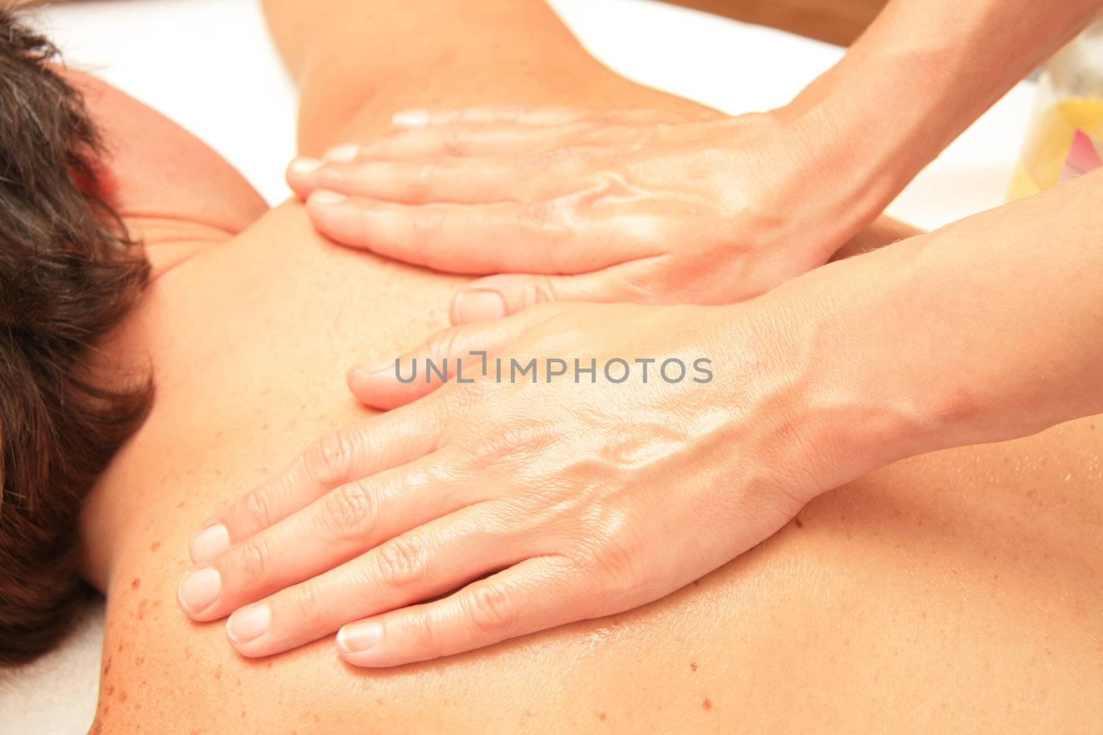 A female masseur giving a back and shoulders massage