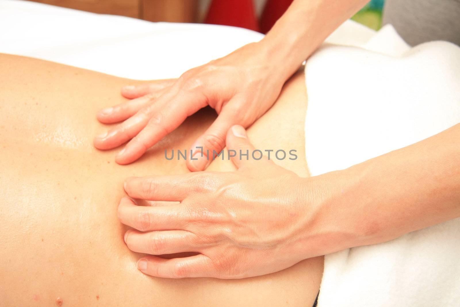 A female masseur giving a back massage