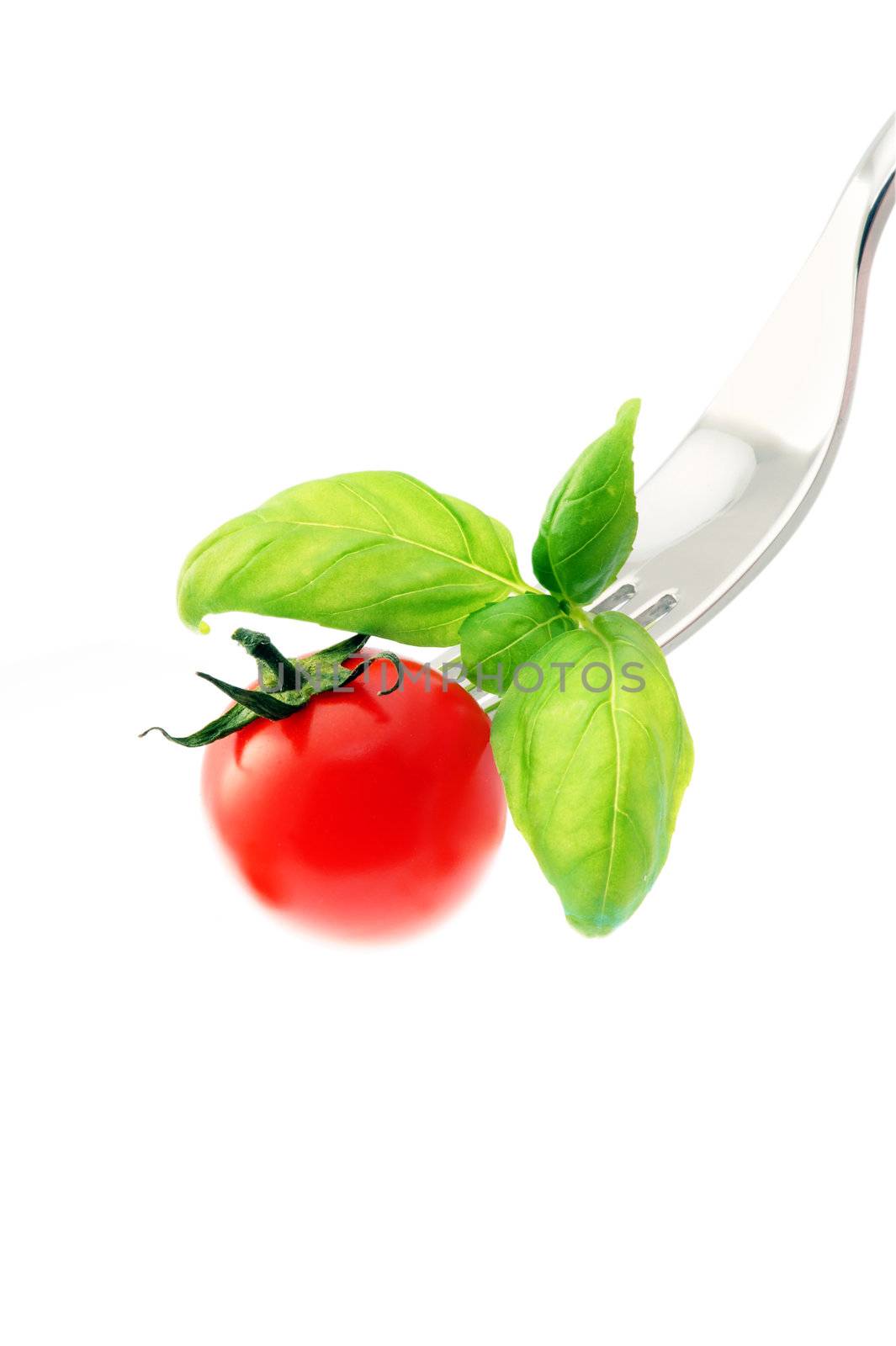 tomato on a fork,isolated on white background by stokkete