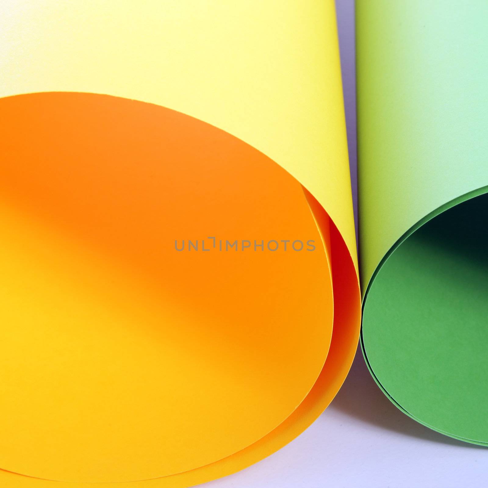 Closeup view of two rolls of colourful cardboard in orange and green for creating posters or artwork lying side by side