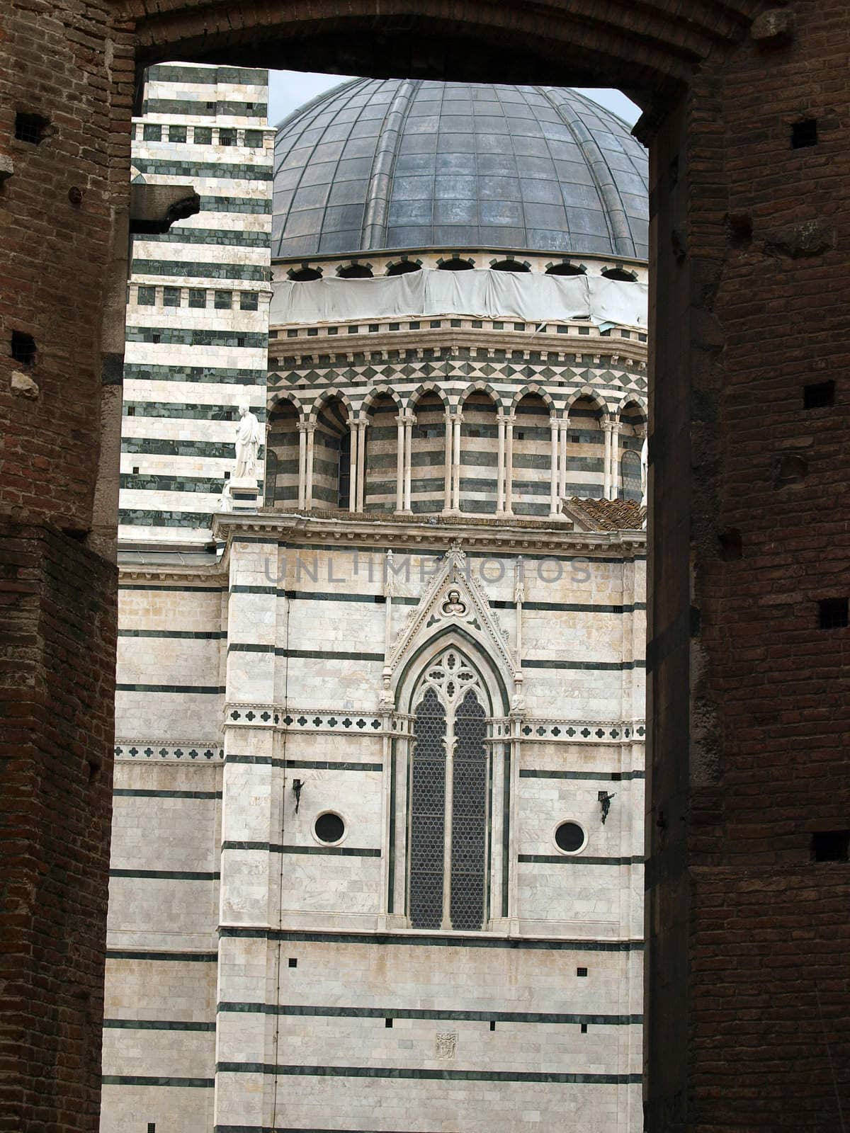 Gates to Duomo of Siena. The Duomo of Siena, which was built in the 12th and 13th centuries, is one of the prettiest churches in Gothic style in Italy