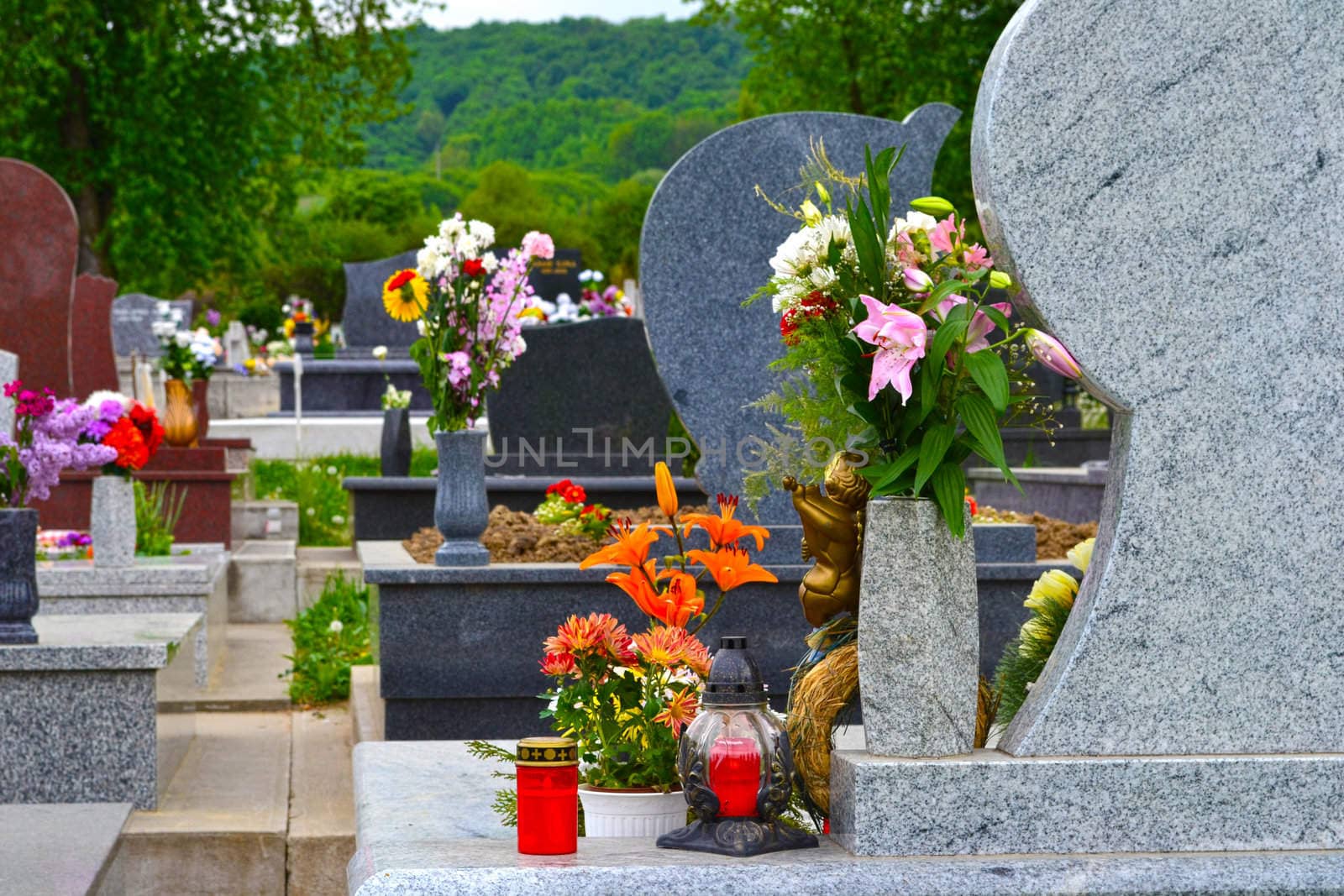 Tidied, well-kept cemetery with beautiful marble tombstones and colourful flowers.