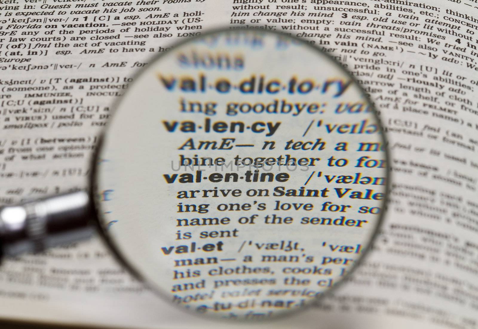 vaentine word in dictionary magnified by hand held magnifying glass