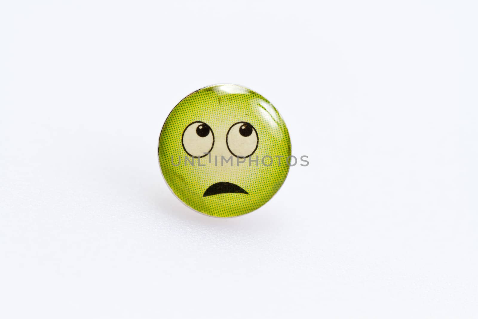 smiley character on metal thumbtack on white surface