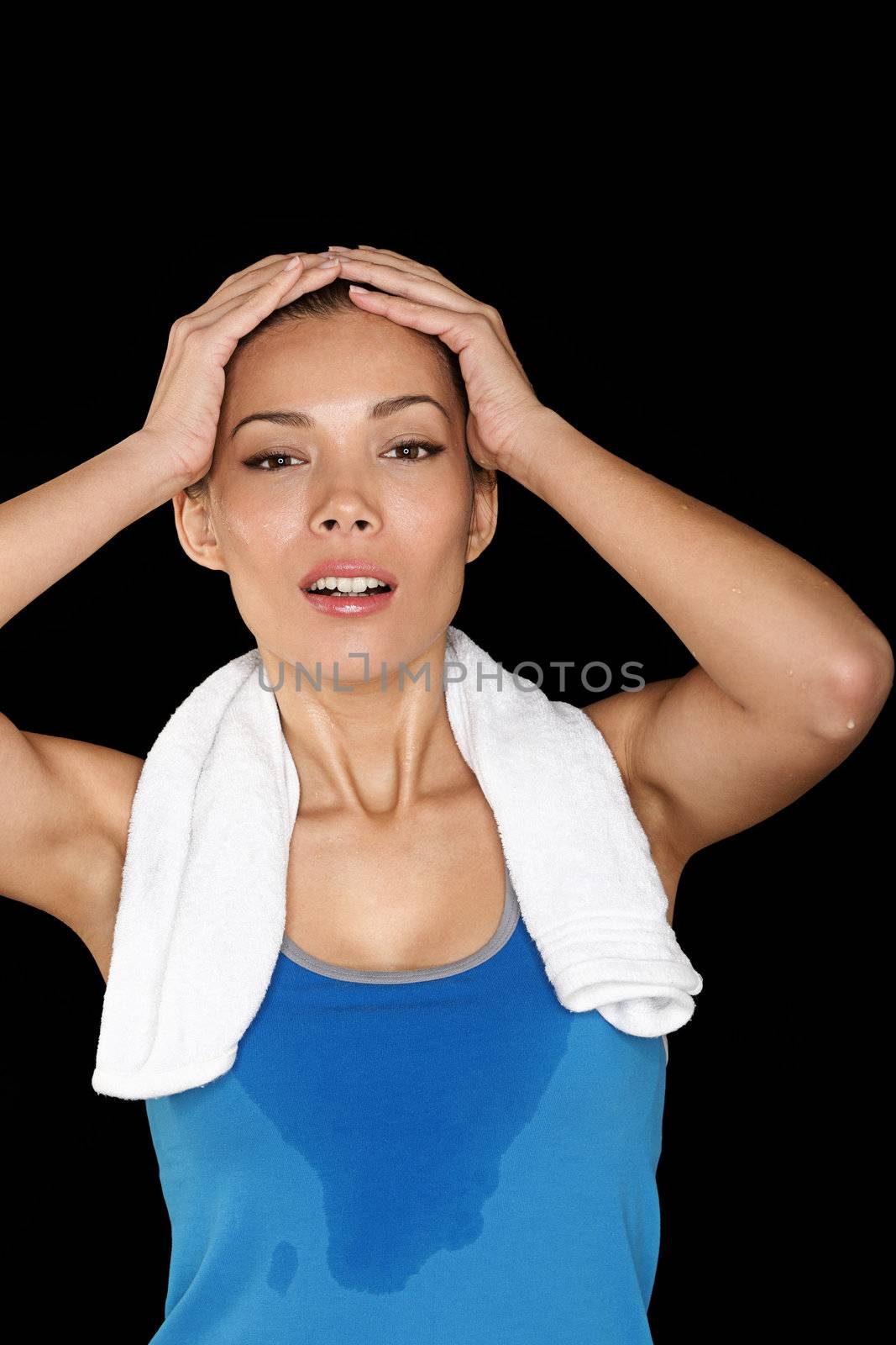Fitness woman sweating. Beautiful sport girl with towel and sweat looking at camera tired, exhausted and sweaty after gym exercise. Multiracial Caucasian / Chinese Asian fit female fitness model isolated on black background.