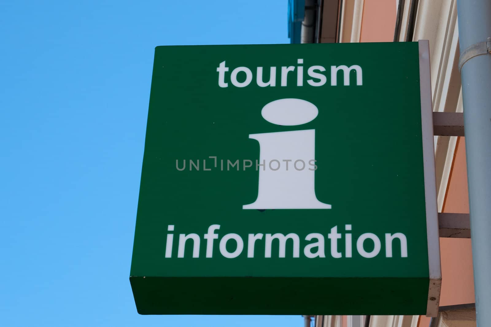 A green wall sign with Tourism