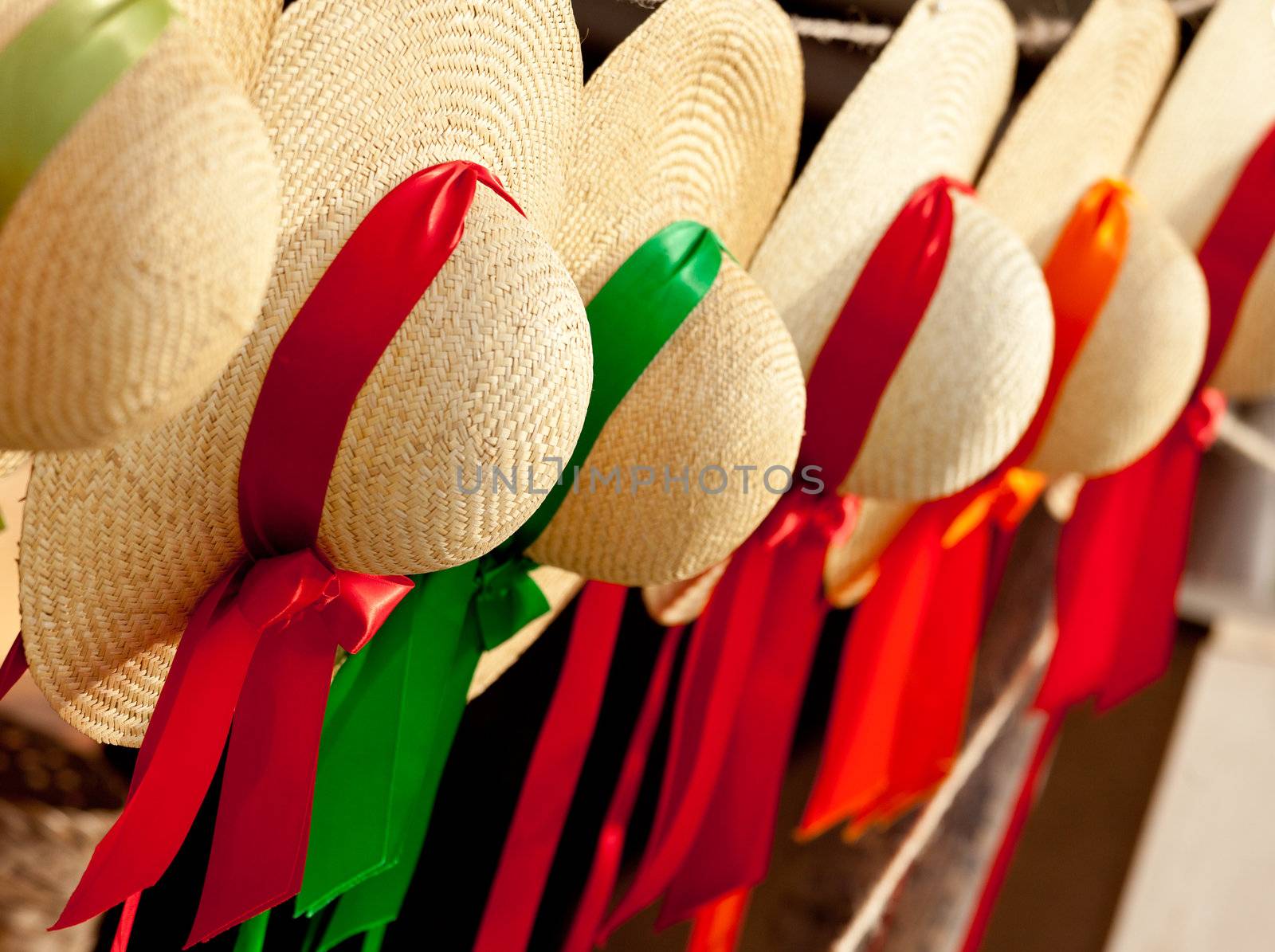 Set of straw woven hats with colorful ribbons in a row