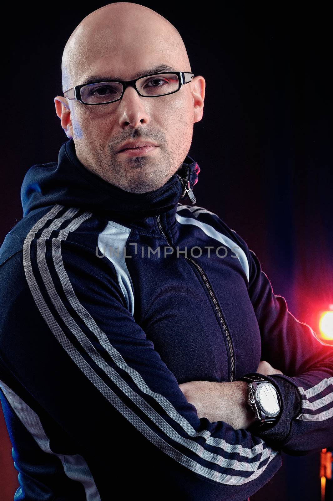 Man with glasses and in a sports suit. Studio-style portrait