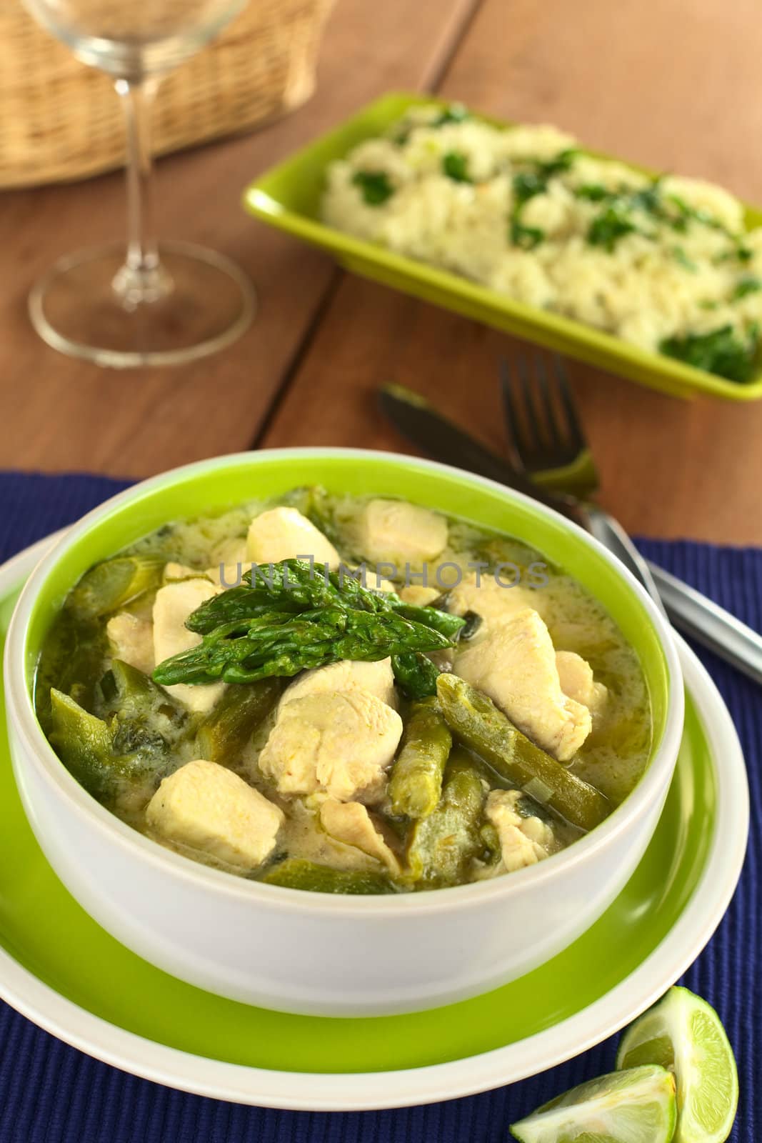 Green asparagus and chicken fricassee with rice in the back (Selective Focus, Focus on the two asparagus tips on the top)