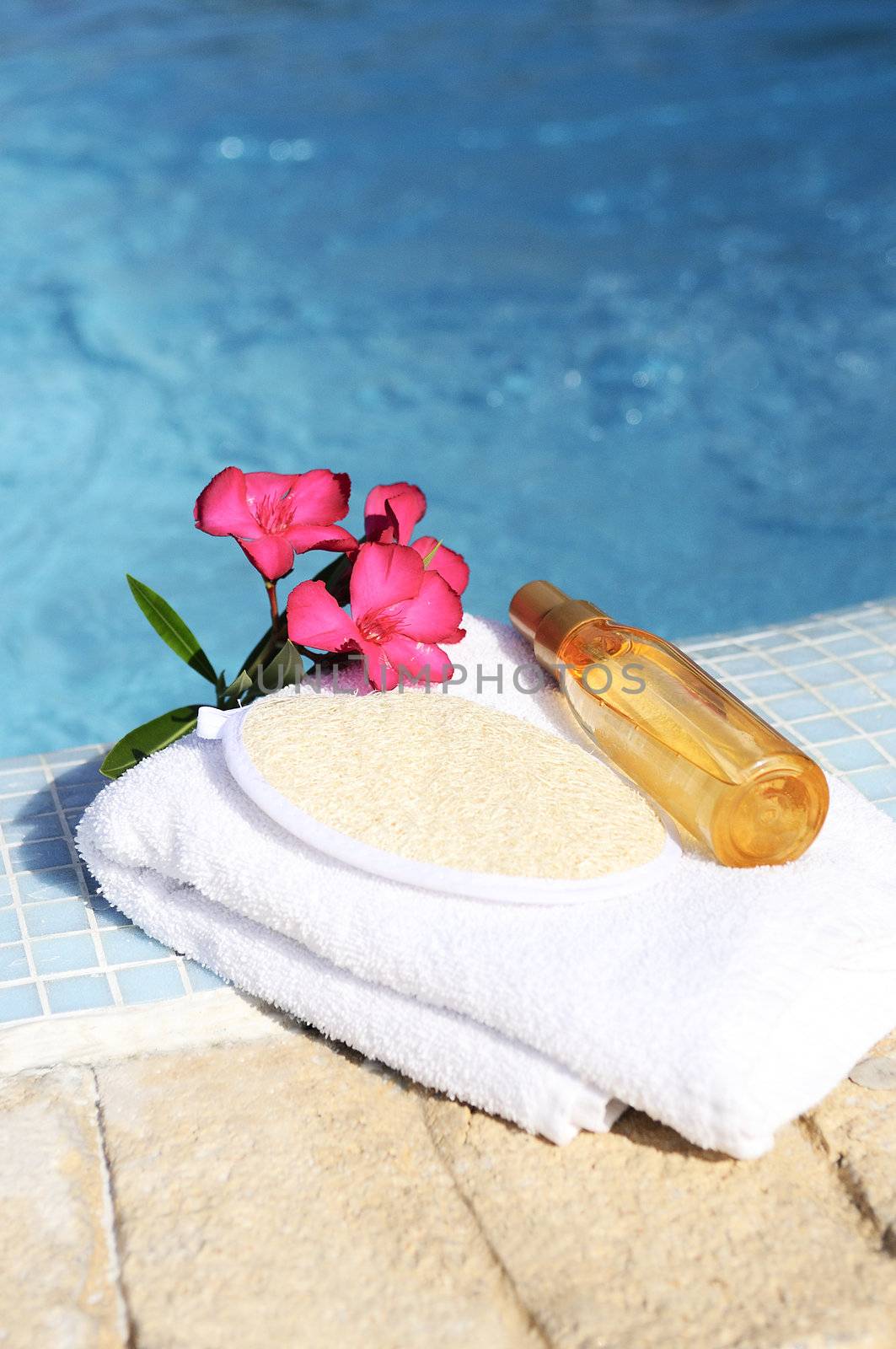 massage oil, shellfish and white towel beside a pool