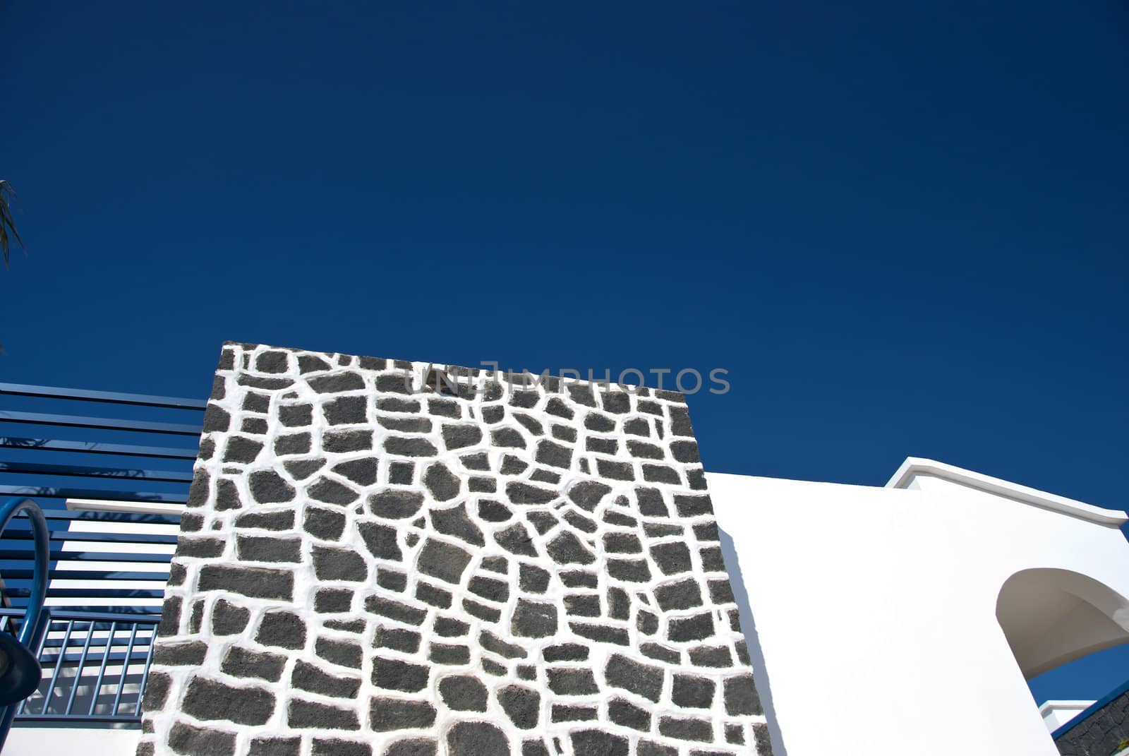 An Abstract Wall of Volcanic Stone against a blue sky
