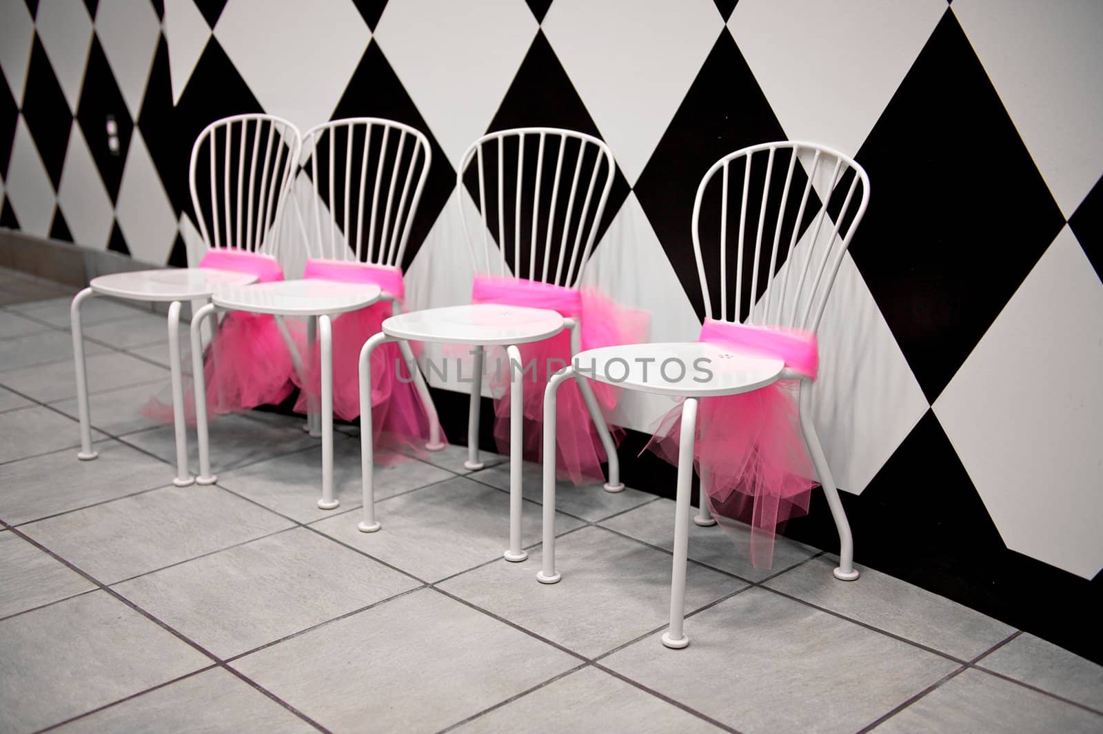 Row of White Chairs with Pink Ribbons by pixelsnap