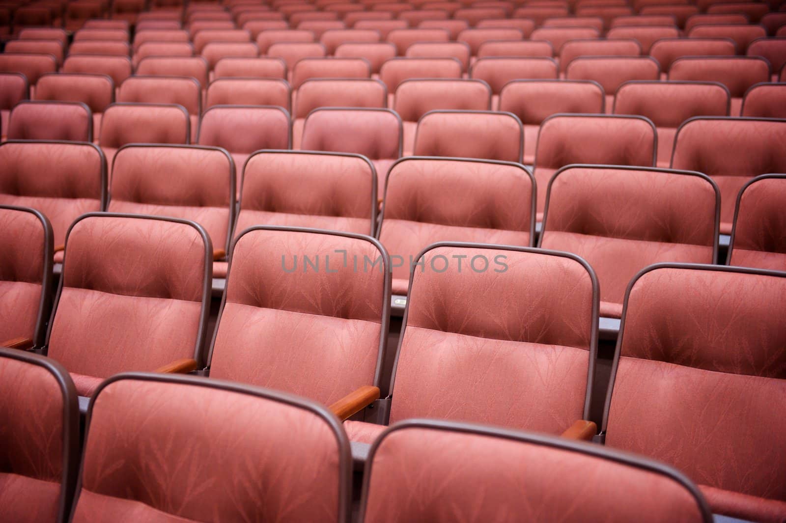 Many Rows of Empty Theatre Seating by pixelsnap