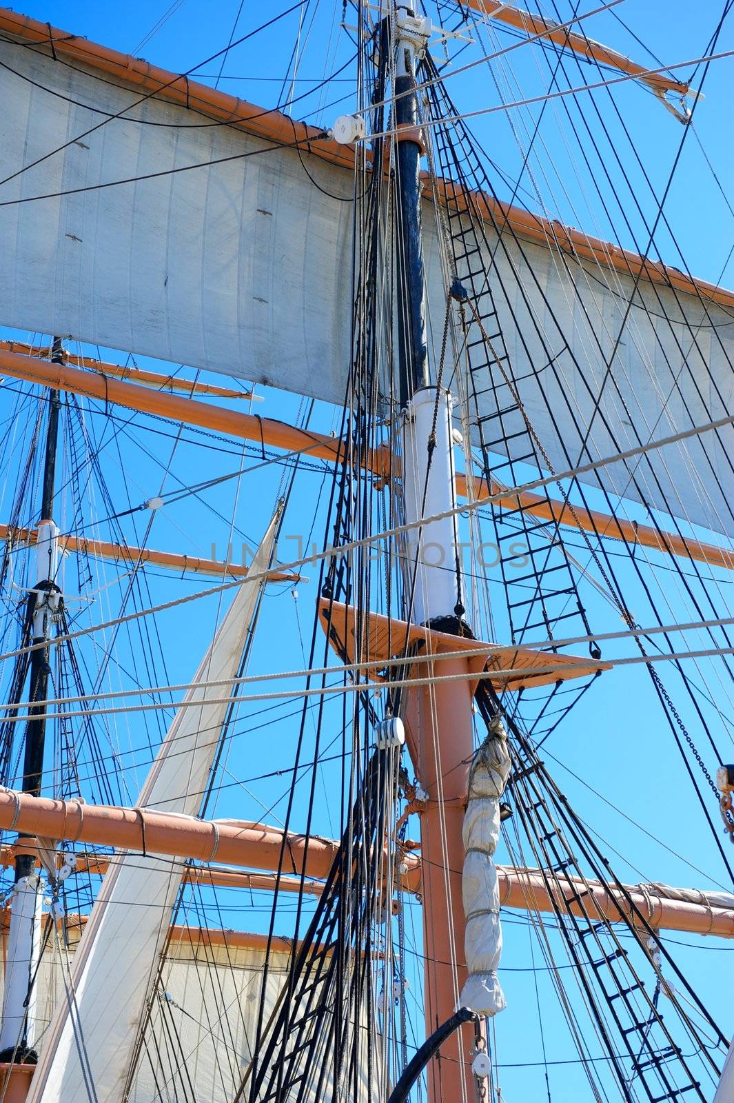 The Sails and Rigging of An Old Sailing Ship Shot Against a Clear Blue Sky