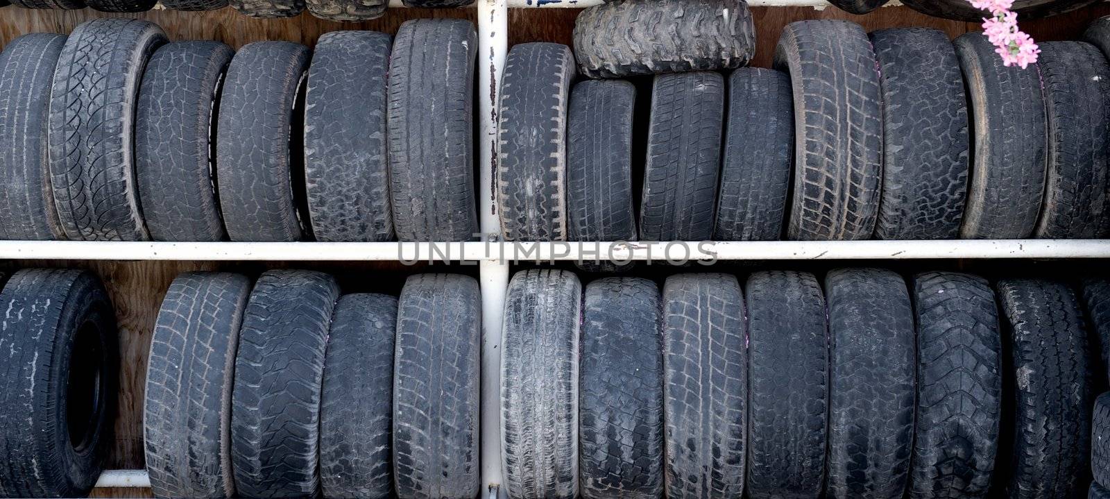 A double rack of old and worn rubber auto tires