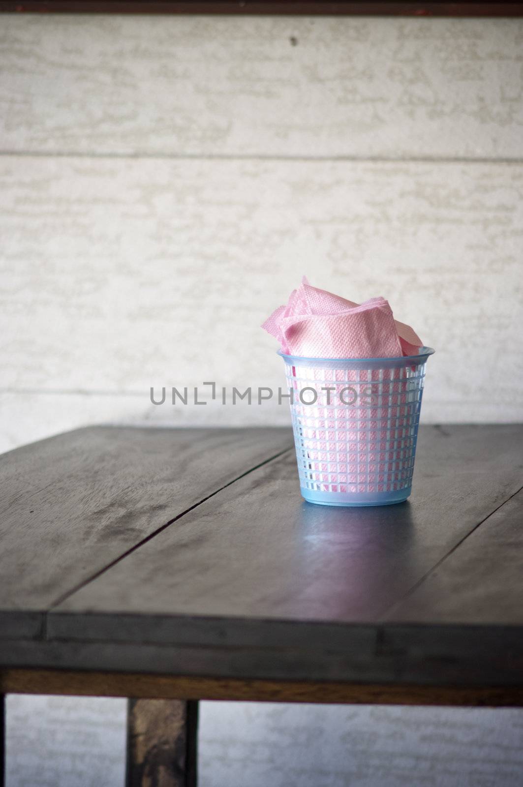 Budget napkin paper in blue basket on wooden table