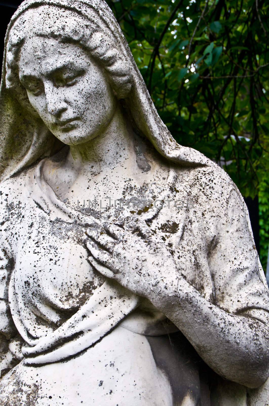 detail of an old tombstone showing a grieving woman