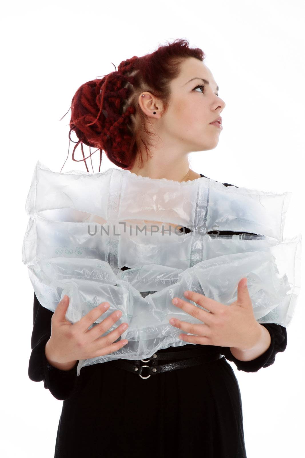 Girl with red hair holds in her hands the air bags imagining that it is a baby on white background

