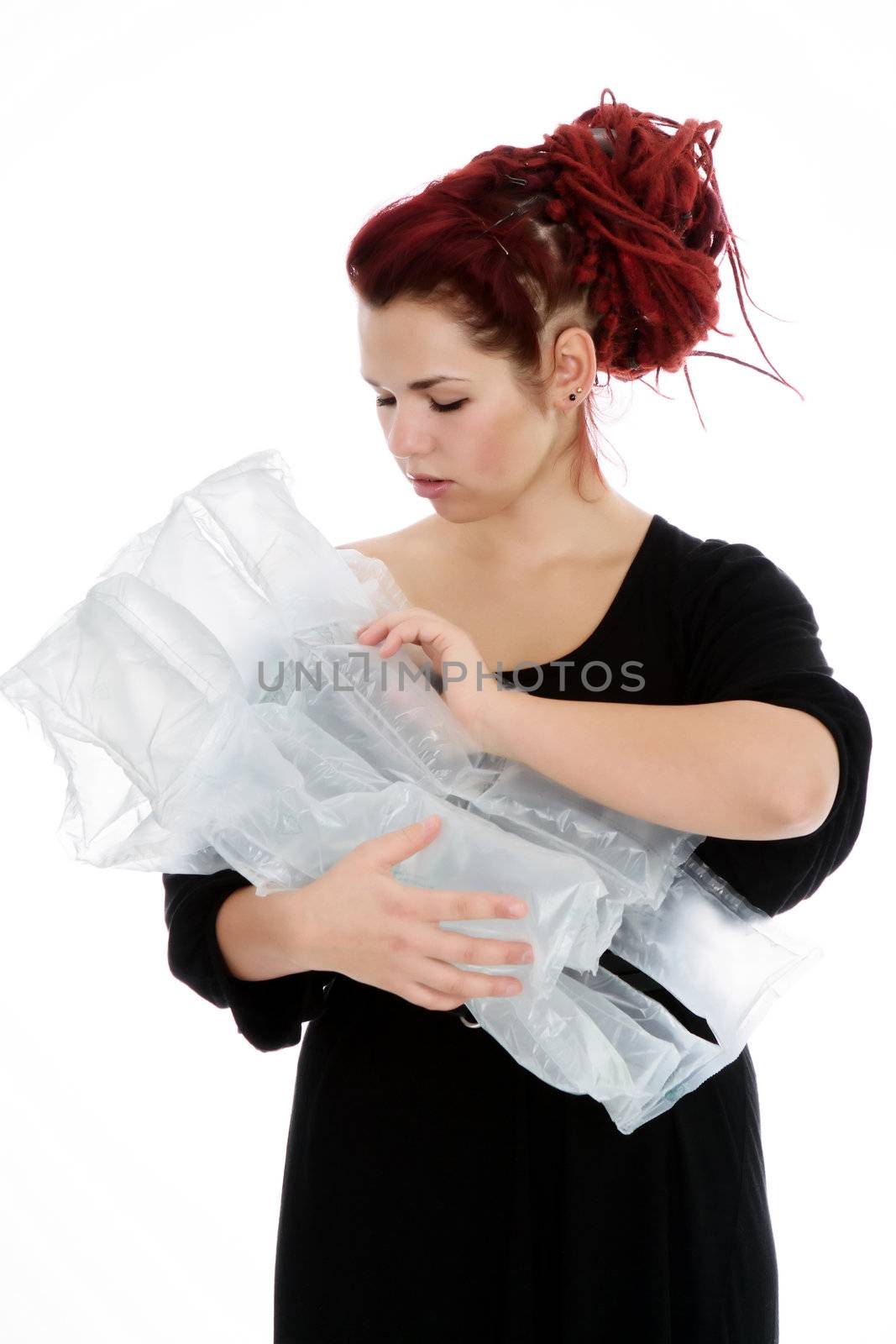 Girl with red hair holds in her hands the air bags imagining that it is a baby on white background
