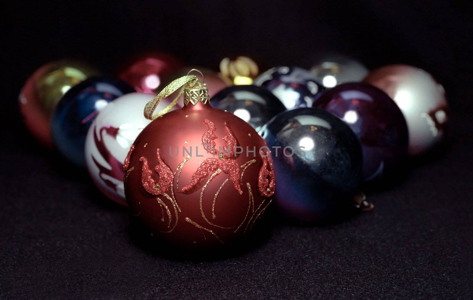 Red glass sphere with Christmas decoration on black background