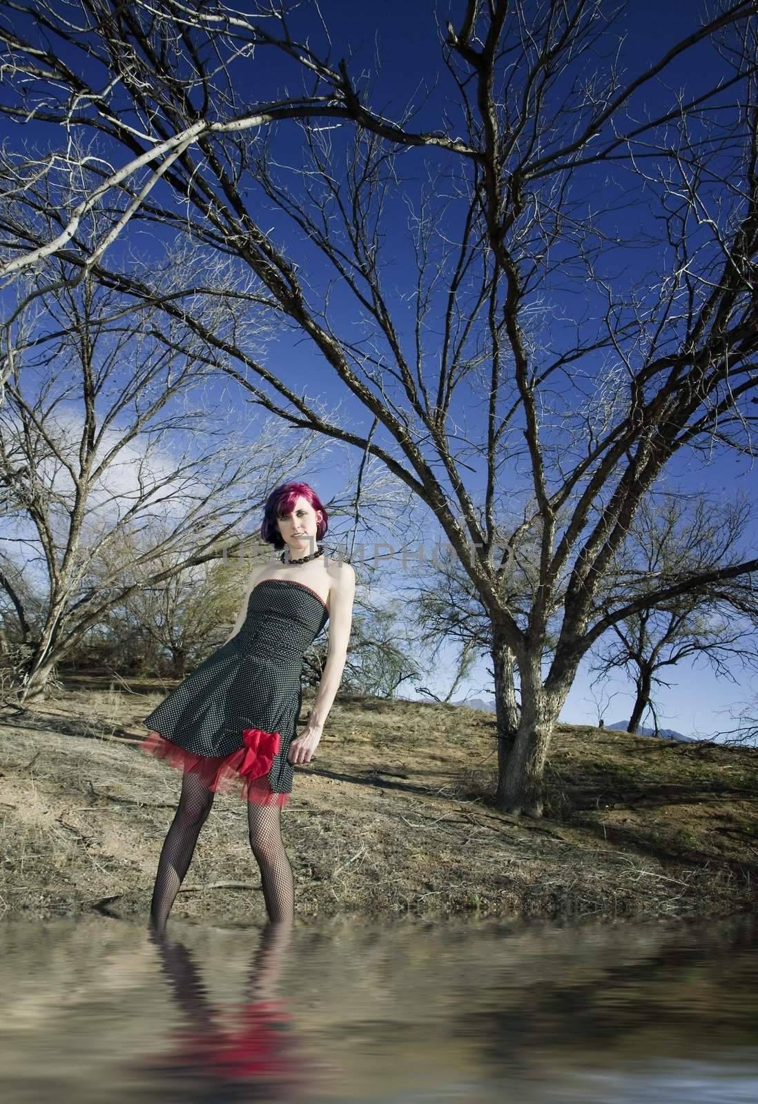 Punk fashion model in front of dead trees