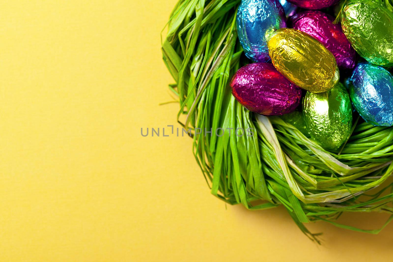 Chocolate easter eggs in green nest. Holiday background. Top view