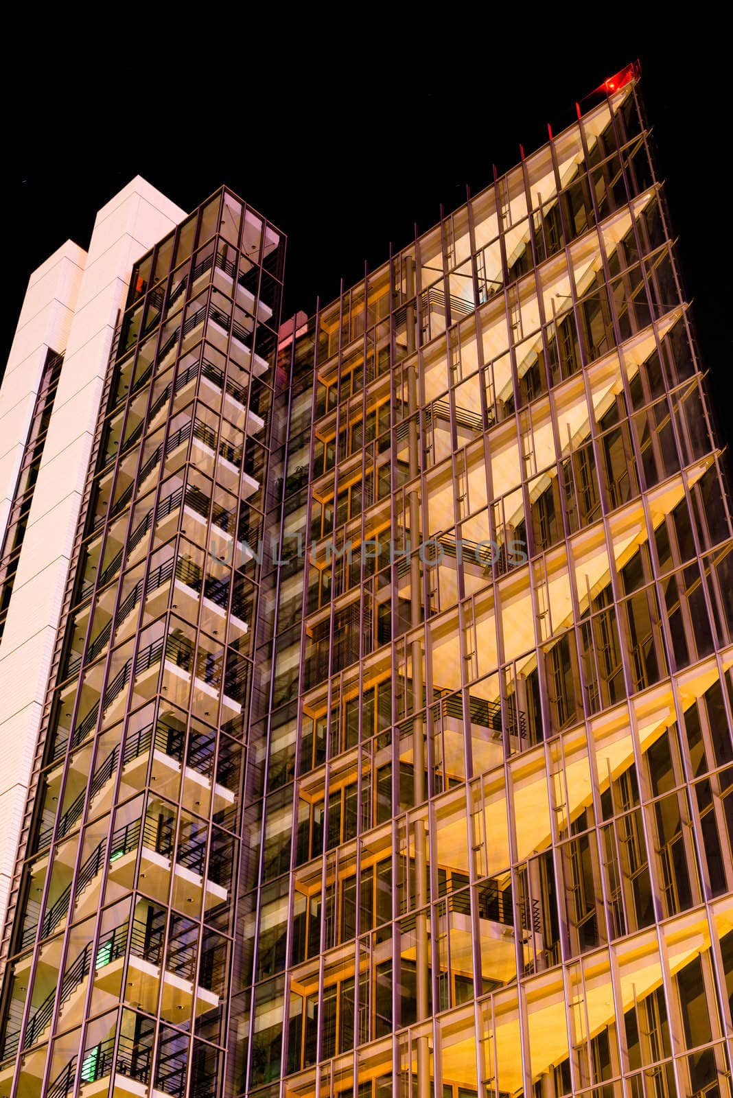 modern multi-storey office building of glass and steel at night