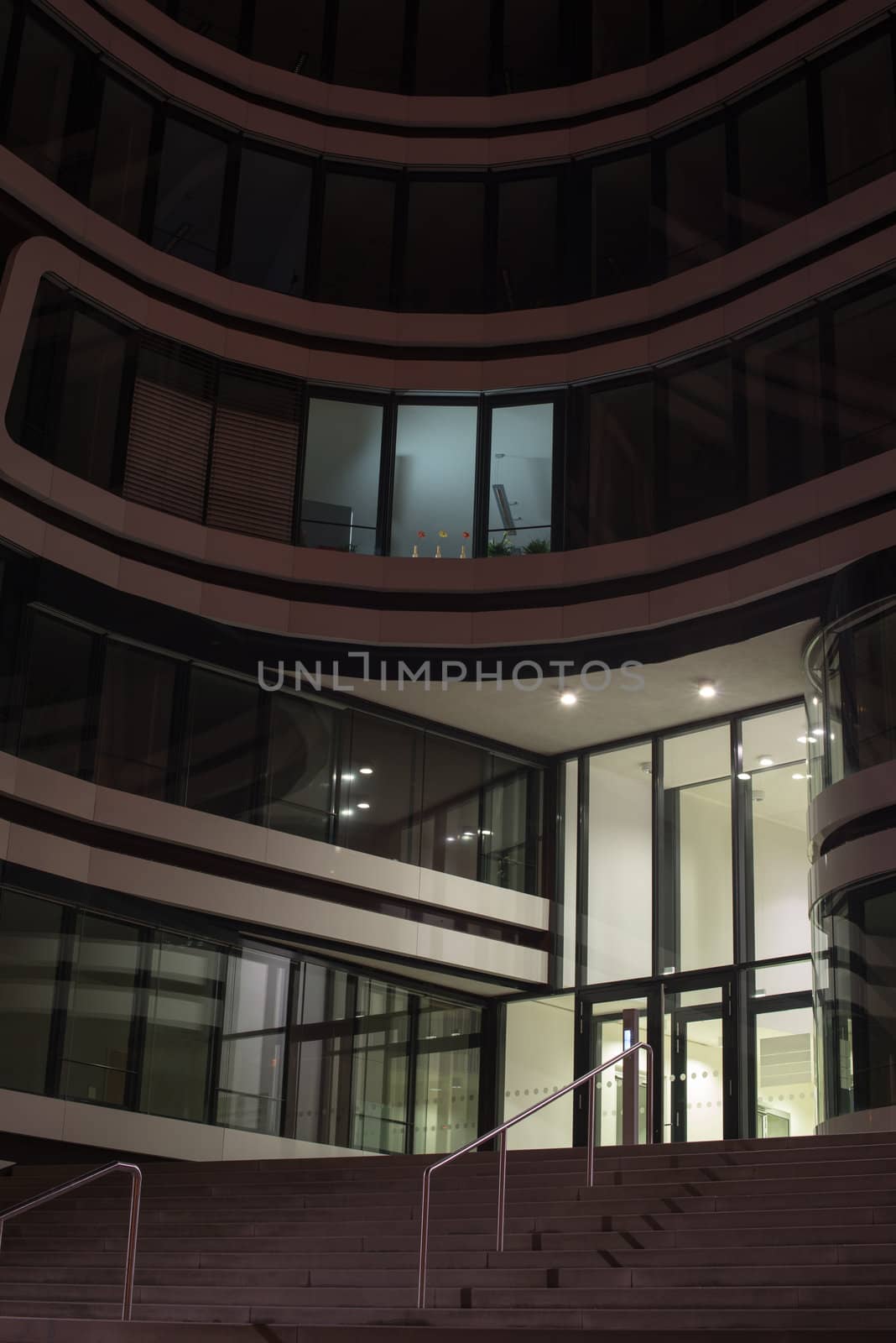 modern multi-storey office building of glass and steel at night