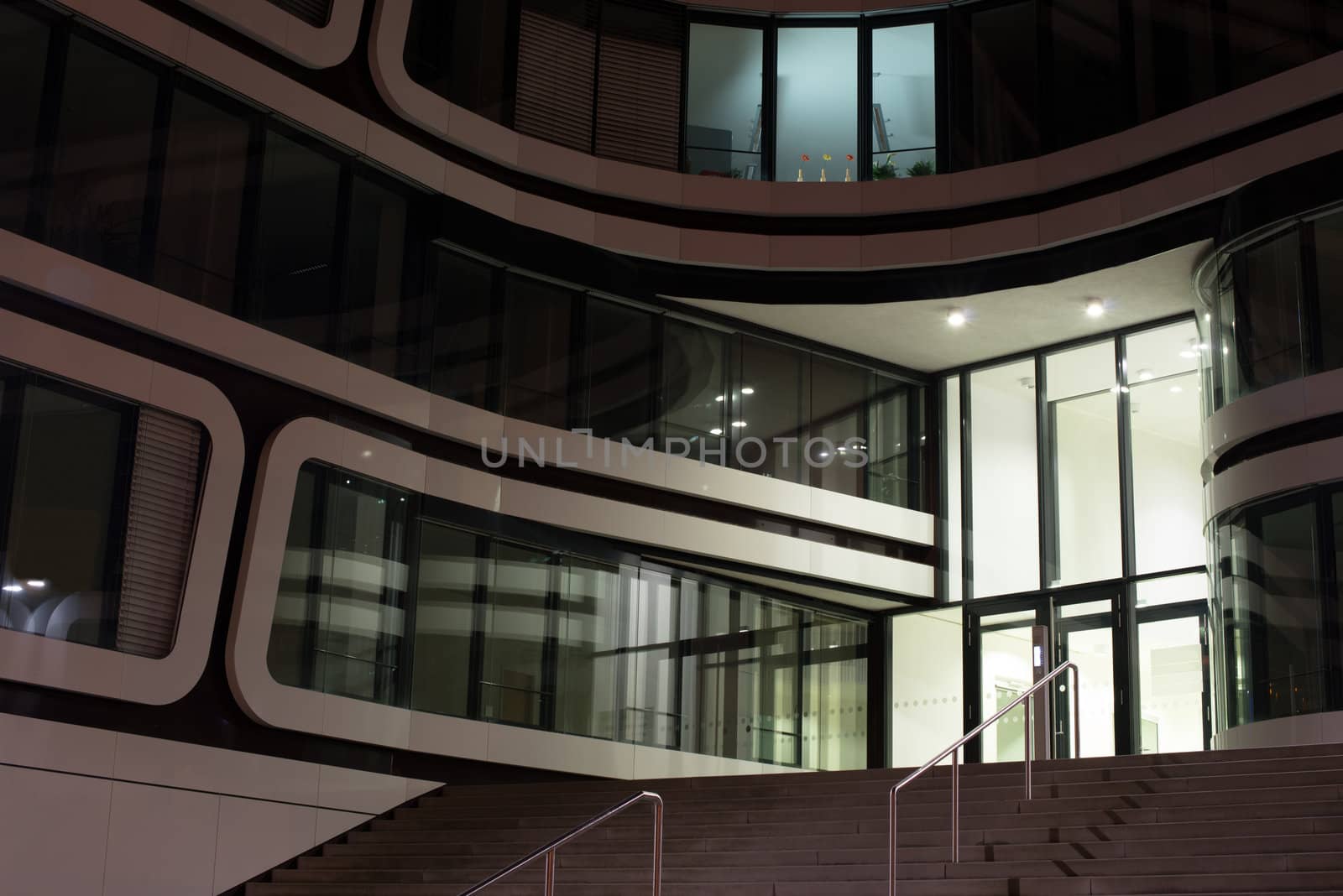 modern multi-storey office building of glass and steel at night