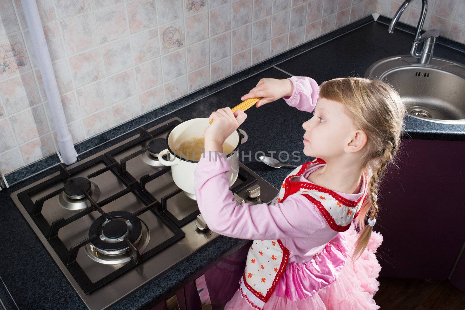 little girl putting pasta in the pot  by vsurkov