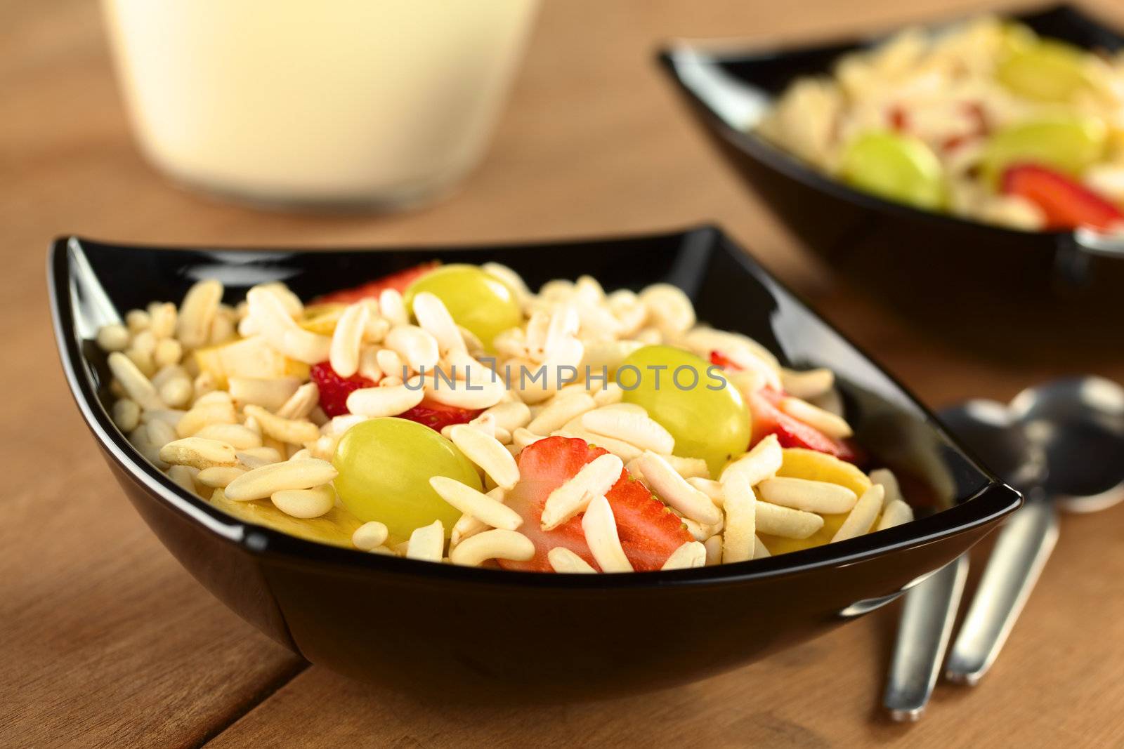 Puffed rice cereal with fresh strawberries, bananas and grapes (Selective Focus, Focus on the strawberry and the grape in the front)