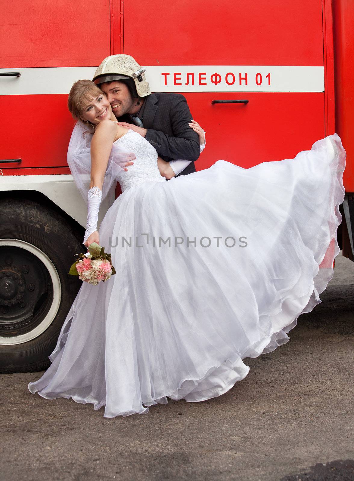 groom and the bride the groom and the bride stand near fire truck